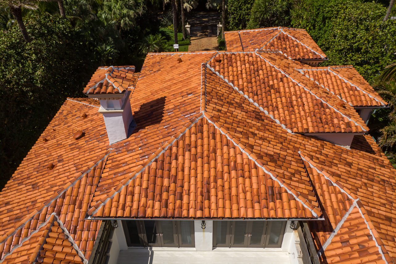 Terracotta ridge tiles and finished roof planes on a completed coastal roof.